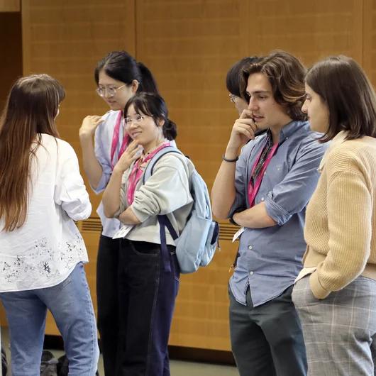 A group of young scientists discussing a research poster.