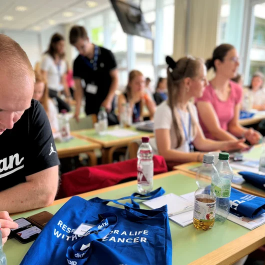 Teilnehmende der Summer School sitzen im Seminarraum an Tischen