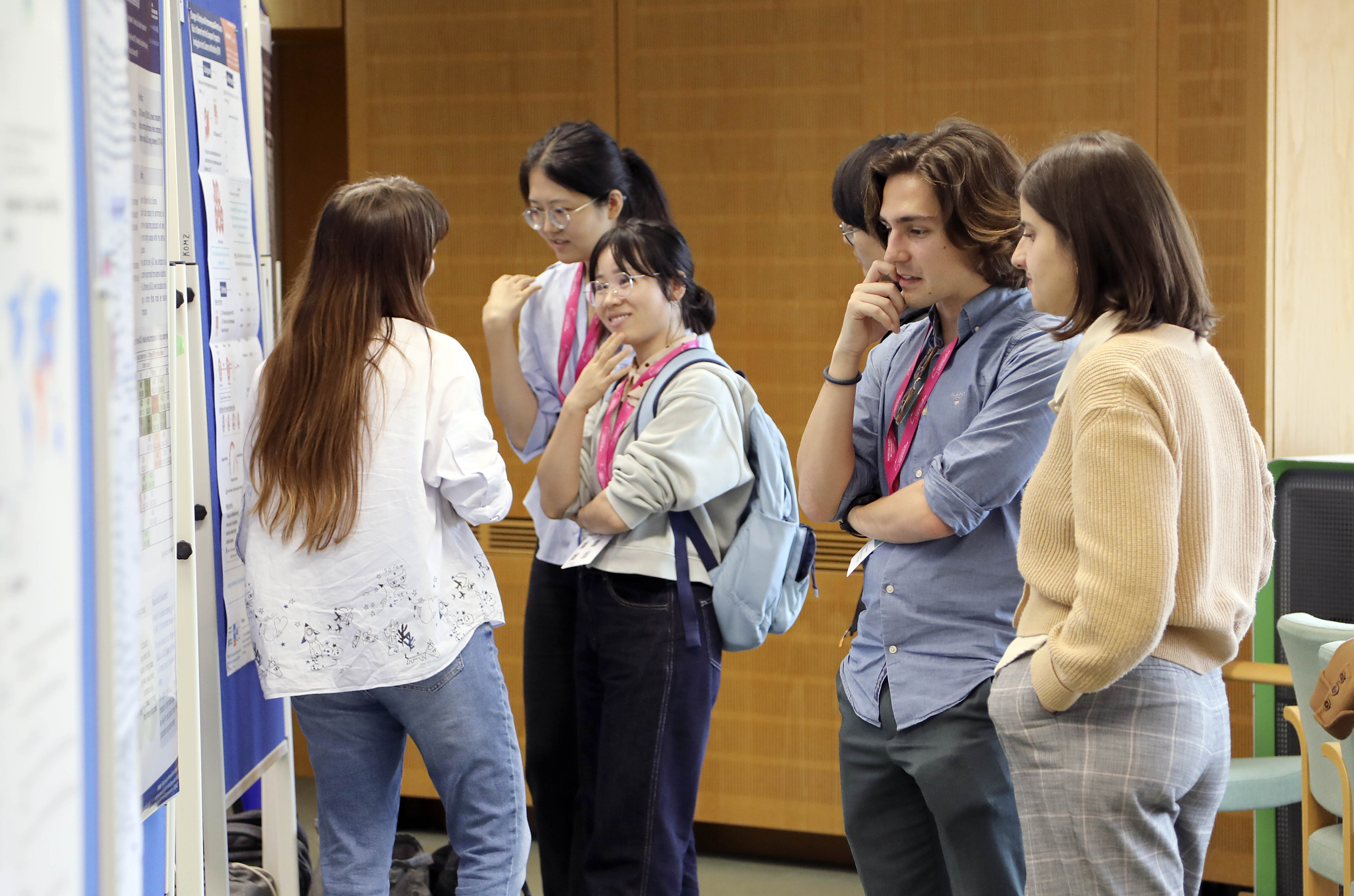 A group of young scientists discussing a research poster.